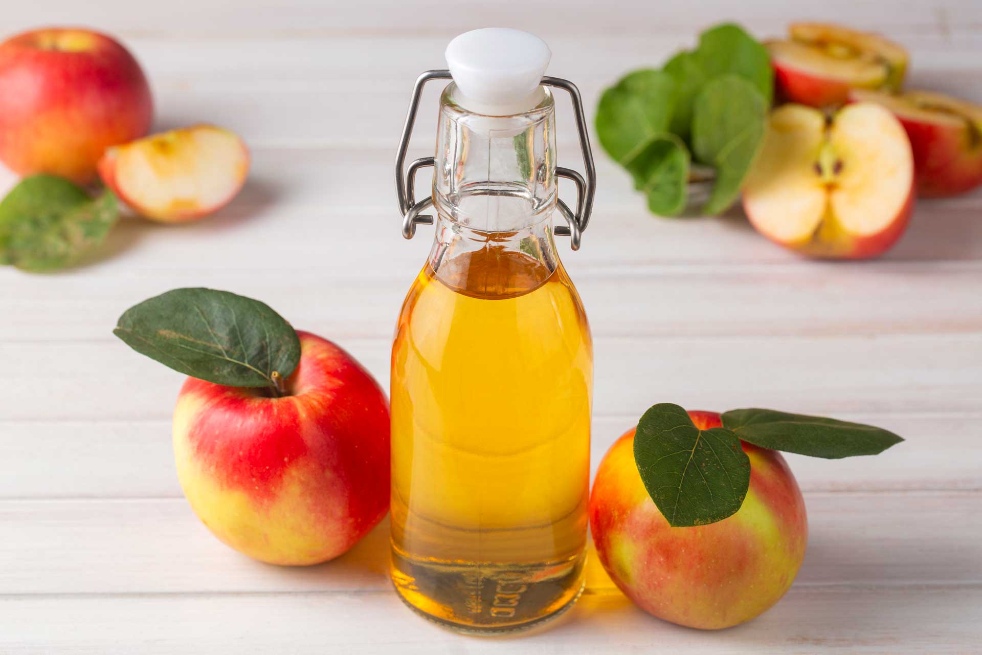Apple cider bottle surrounded by apples