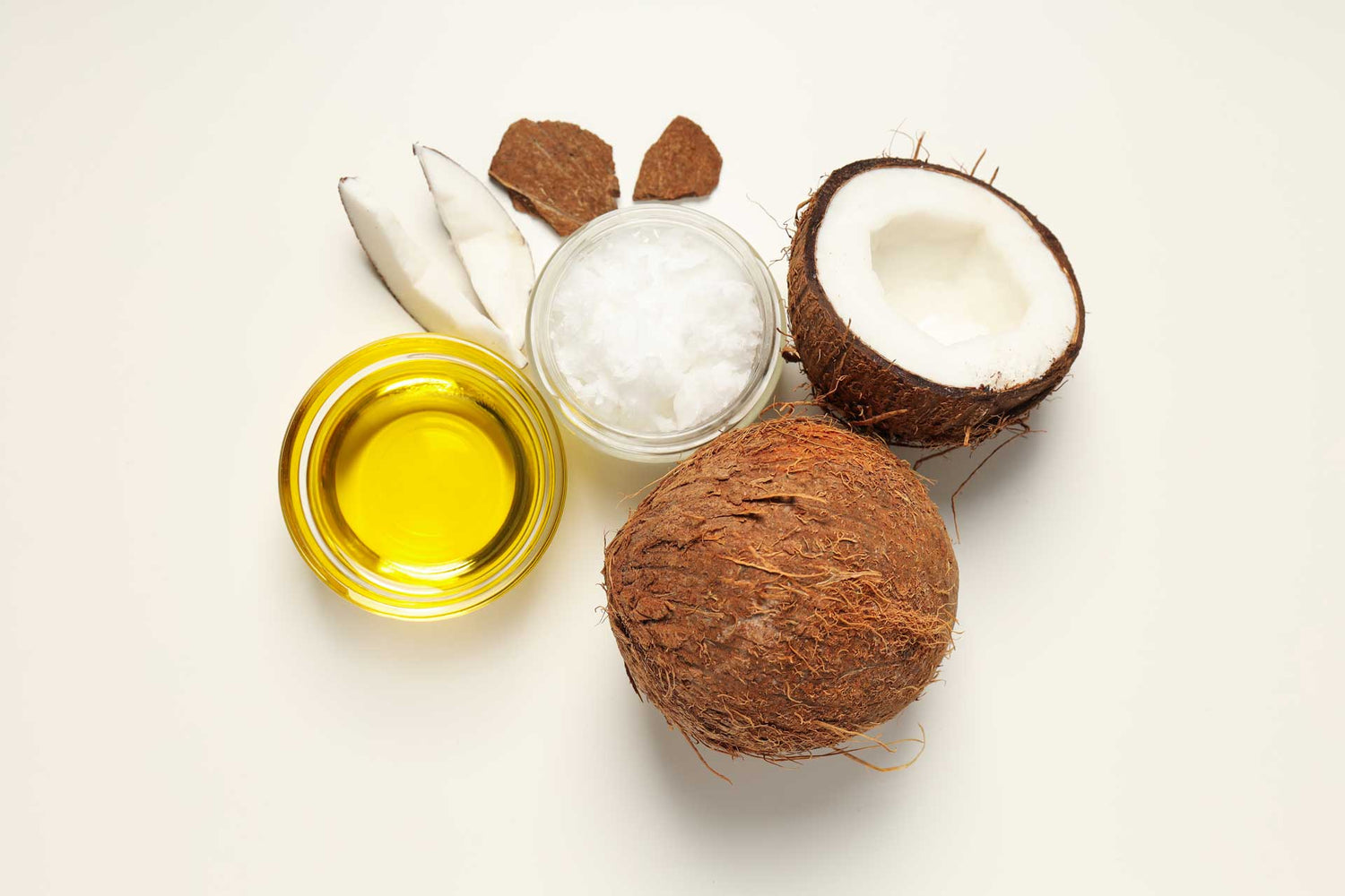 coconut split in half and coconut oil in a glass