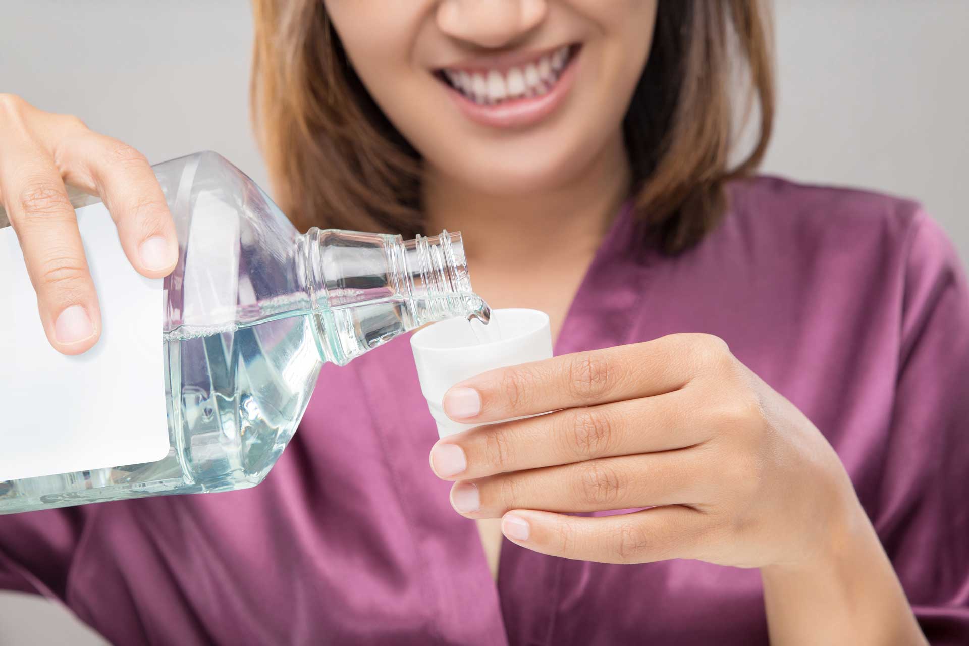 Lady poring Listerine in a little cup